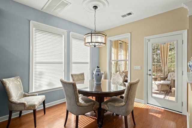 dining area with light wood-style flooring, visible vents, and baseboards