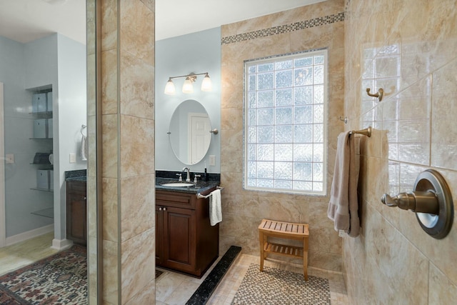 full bath featuring tile patterned flooring, tile walls, and vanity