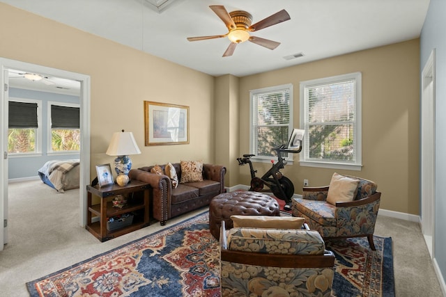 carpeted living room featuring a ceiling fan, attic access, visible vents, and baseboards