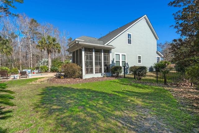 rear view of house featuring a lawn, a patio area, fence, and a sunroom