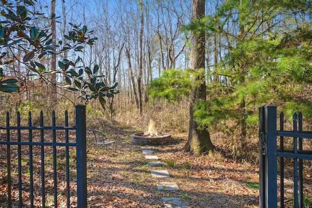 view of gate with a fire pit and fence