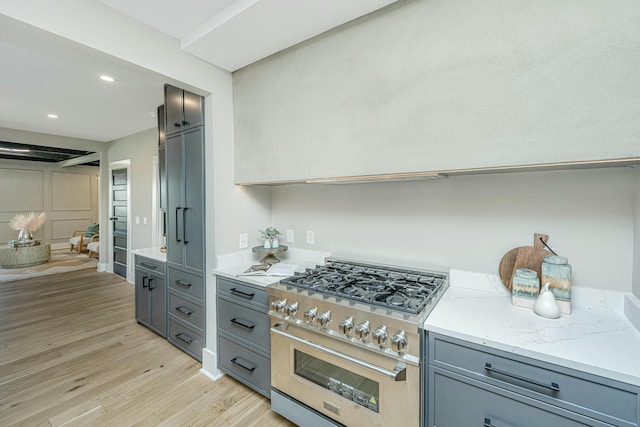kitchen with recessed lighting, light wood finished floors, gray cabinetry, and high end stainless steel range oven