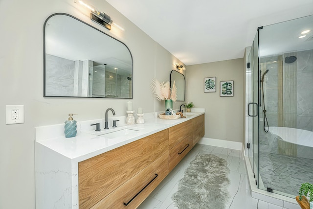 bathroom with a shower stall, marble finish floor, a sink, double vanity, and baseboards