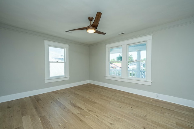 spare room with crown molding, baseboards, and visible vents