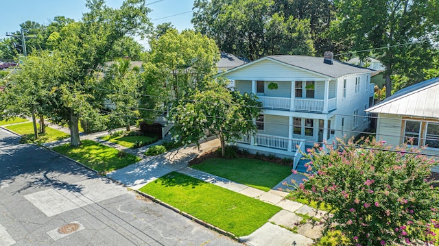 view of front of property featuring a front yard, a porch, and a chimney