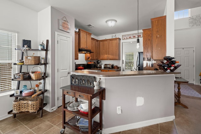 216 Goldfinch Ln, Summerville, SC 29485 - kitchen featuring under cabinet range hood, freestanding refrigerator, a kitchen bar, and tile patterned flooring