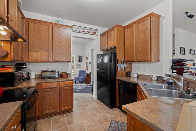 216 Goldfinch Ln, Summerville, SC 29485 - kitchen with black appliances, a sink, brown cabinetry, under cabinet range hood, and light tile patterned floors