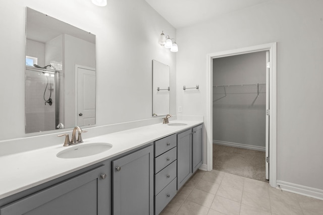 bathroom featuring tile patterned flooring, a shower with door, and vanity