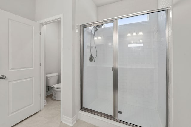 bathroom with a shower with shower door, toilet, and tile patterned floors