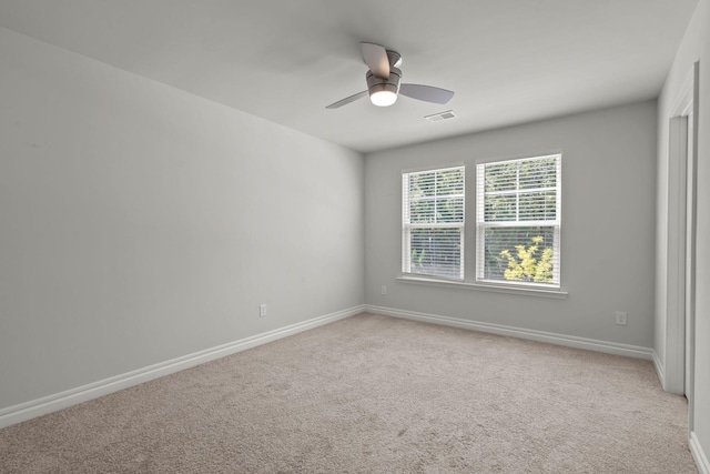 carpeted spare room with ceiling fan