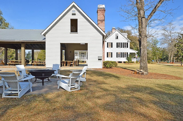 rear view of property with a fire pit, a gazebo, a lawn, and a patio