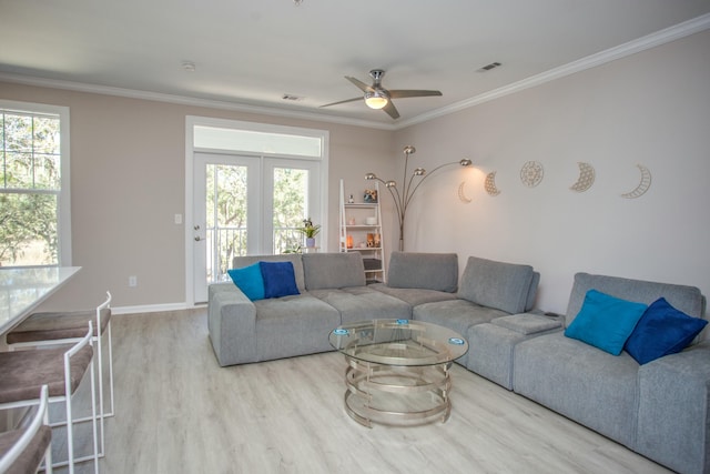 living room featuring ornamental molding, a ceiling fan, visible vents, and wood finished floors