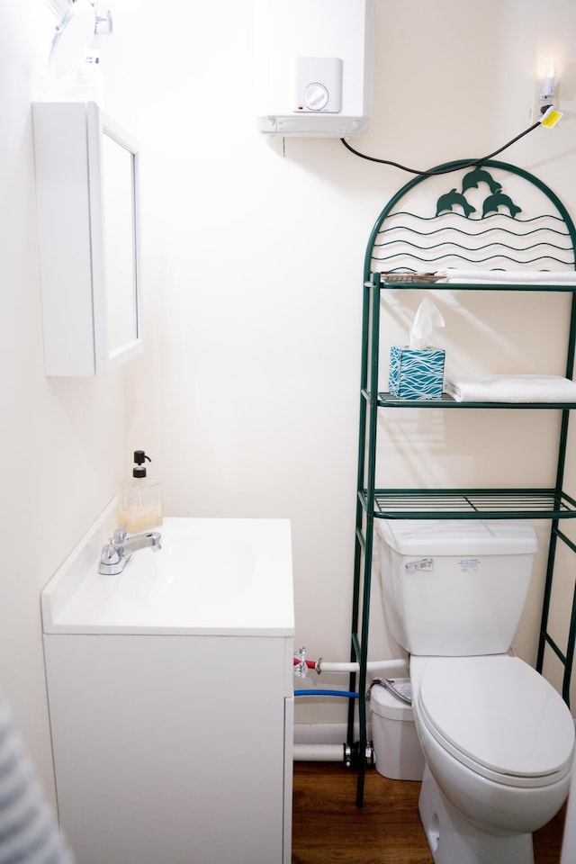 bathroom featuring toilet, wood finished floors, and vanity