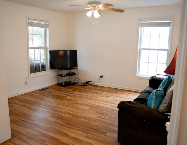 living area featuring plenty of natural light, wood finished floors, and baseboards