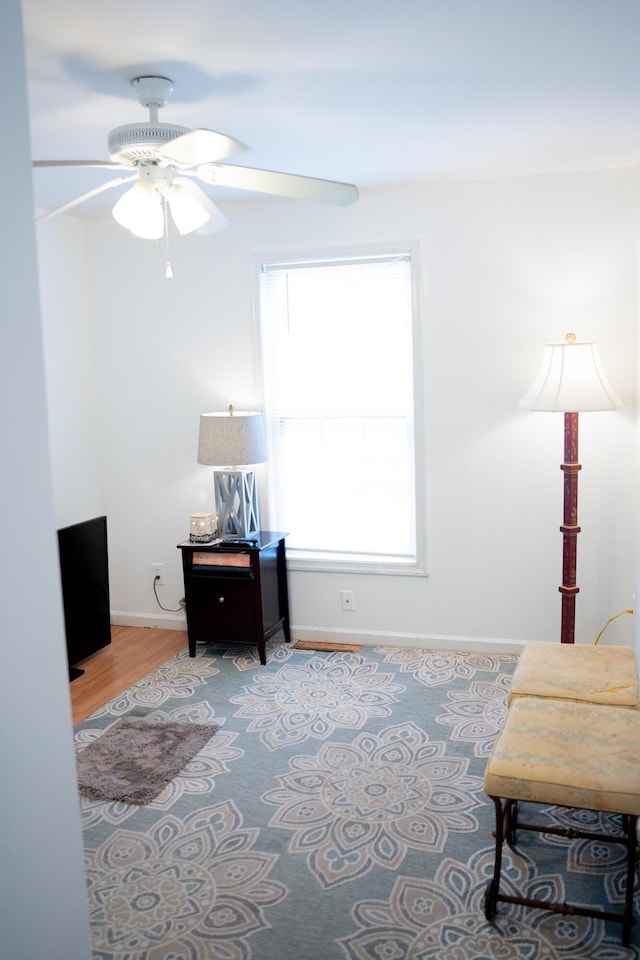 living area featuring ceiling fan, wood finished floors, and baseboards