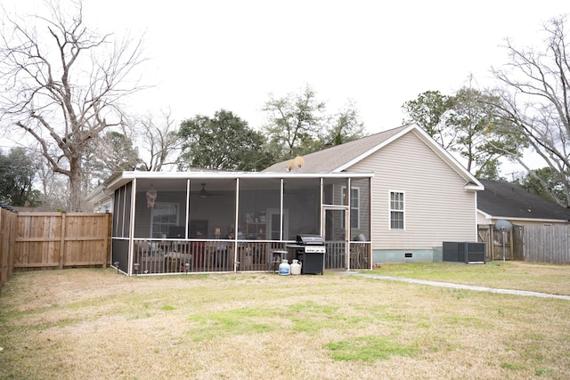 back of property with crawl space, a lawn, a fenced backyard, and a sunroom