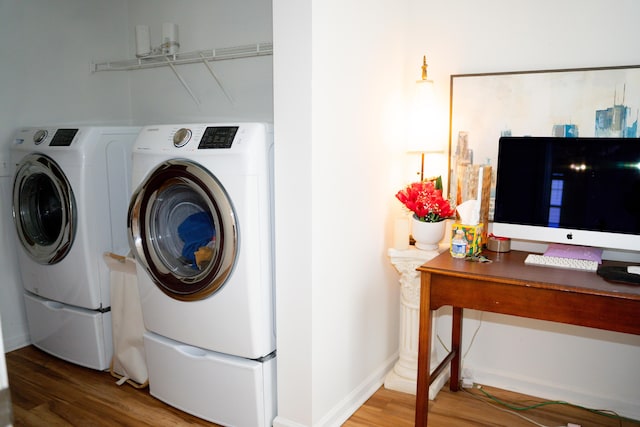 laundry area featuring light wood-type flooring, independent washer and dryer, laundry area, and baseboards