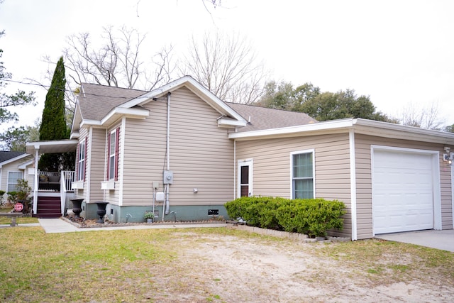 view of side of home featuring a garage, roof with shingles, crawl space, and a lawn