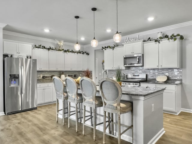 209 Celestial Blvd, Summerville, SC 29486 - kitchen featuring appliances with stainless steel finishes, backsplash, ornamental molding, an island with sink, and white cabinetry