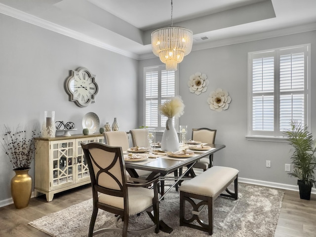 209 Celestial Blvd, Summerville, SC 29486 - dining space with a tray ceiling, a chandelier, wood finished floors, baseboards, and ornamental molding