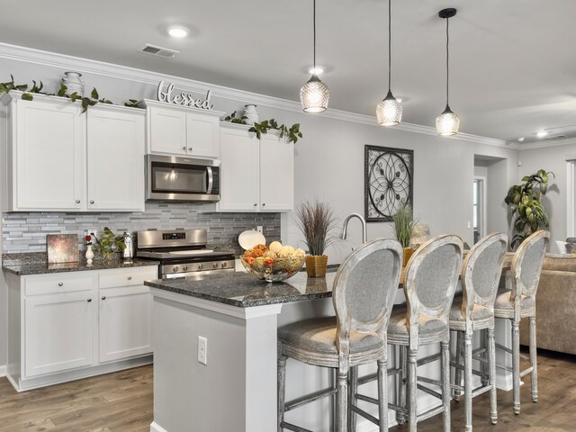 209 Celestial Blvd, Summerville, SC 29486 - kitchen featuring appliances with stainless steel finishes, dark stone counters, backsplash, ornamental molding, and recessed lighting