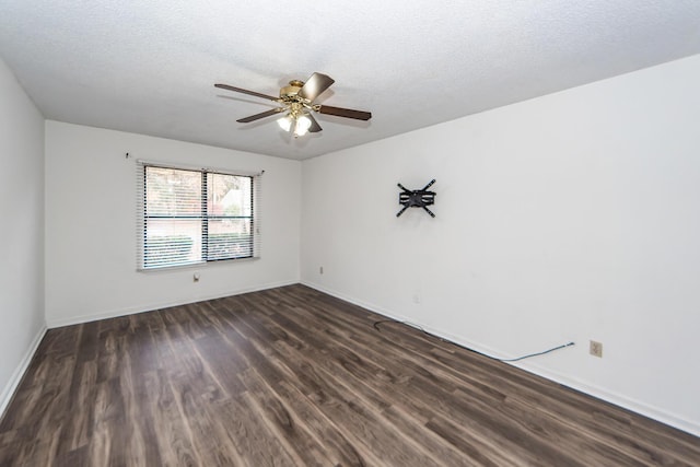 spare room featuring ceiling fan, dark wood-type flooring, and a textured ceiling