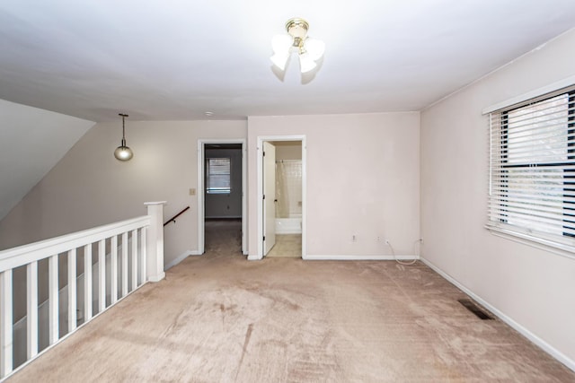 carpeted spare room with vaulted ceiling