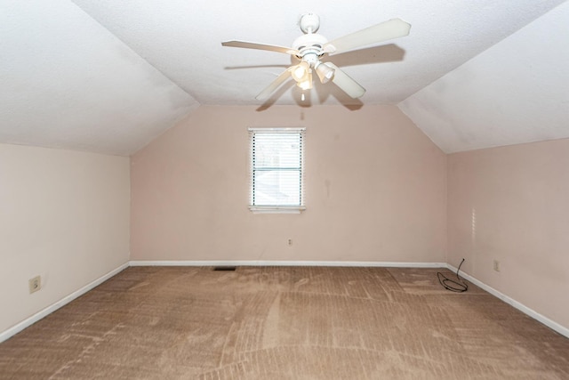 additional living space with light carpet, a textured ceiling, ceiling fan, and lofted ceiling