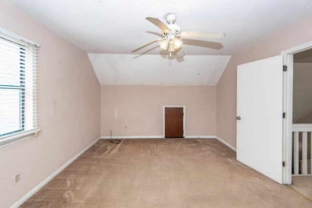 additional living space featuring a wealth of natural light, light colored carpet, and vaulted ceiling