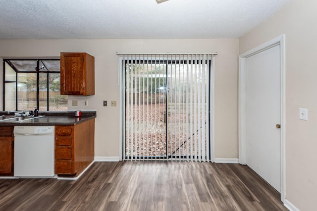 kitchen featuring dishwasher, a textured ceiling, dark hardwood / wood-style floors, and sink