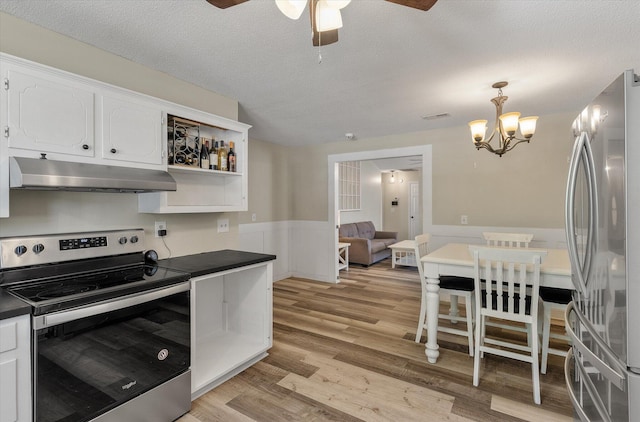 5052 Hidden Forest Ln, North Charleston, SC 29420 - kitchen featuring under cabinet range hood, appliances with stainless steel finishes, dark countertops, wainscoting, and white cabinets