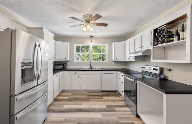 5052 Hidden Forest Ln, North Charleston, SC 29420 - kitchen featuring stainless steel appliances, under cabinet range hood, dark countertops, a ceiling fan, and light wood-type flooring
