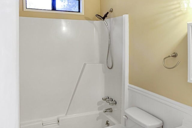 bathroom with bathtub / shower combination and toilet