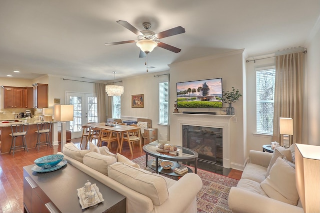 living area featuring ceiling fan, a fireplace with flush hearth, recessed lighting, french doors, and wood finished floors