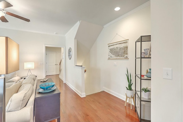 living area featuring a ceiling fan, baseboards, recessed lighting, ornamental molding, and light wood-type flooring