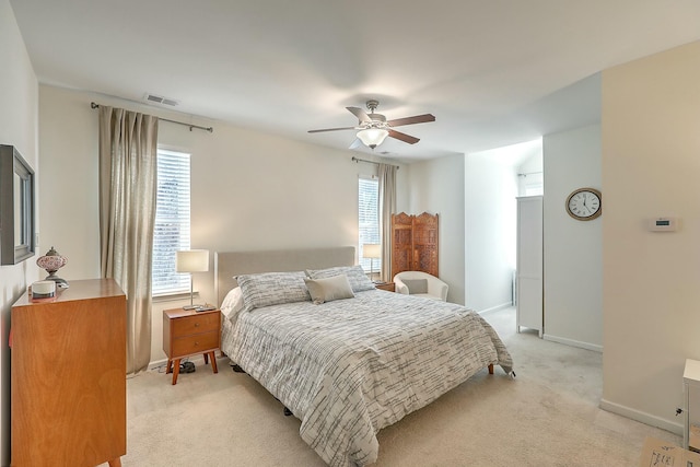 bedroom featuring visible vents, multiple windows, light carpet, and a ceiling fan