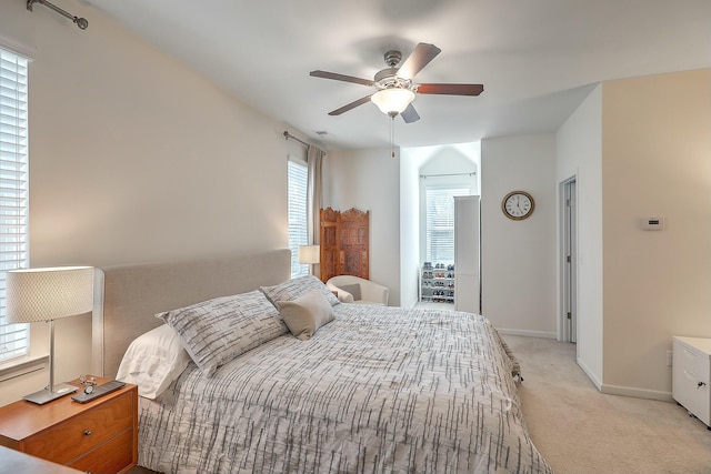 bedroom with light carpet, visible vents, a ceiling fan, and baseboards