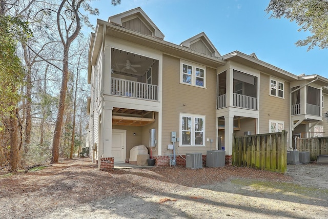 view of front facade with central AC unit, board and batten siding, and ceiling fan