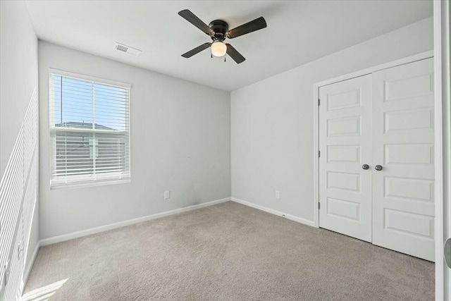 empty room with ceiling fan and light carpet