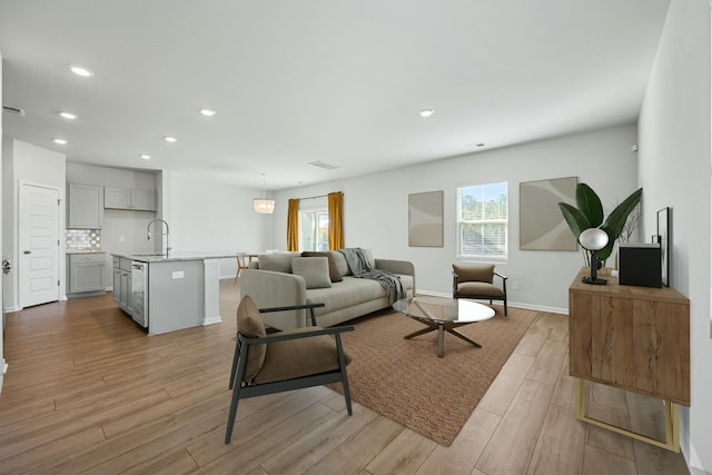 living room with sink and light hardwood / wood-style floors