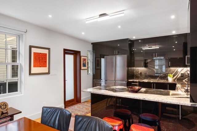 301 Broad St Unit 1, Charleston, SC 29401 - kitchen featuring freestanding refrigerator, a kitchen bar, modern cabinets, a peninsula, and backsplash