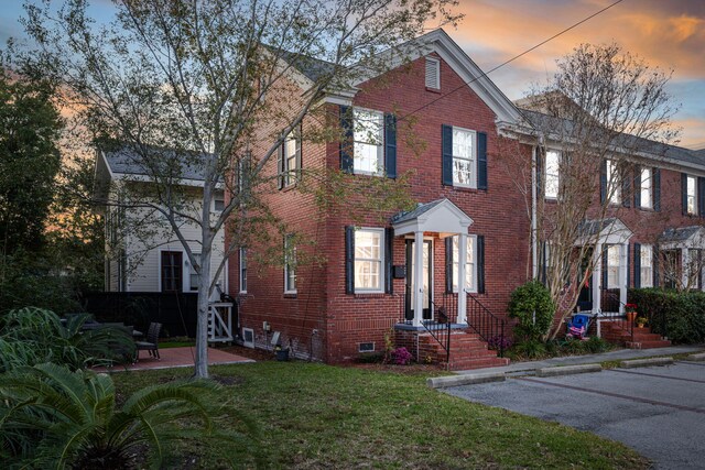 301 Broad St Unit 1, Charleston, SC 29401 - view of front of home with brick siding, a yard, and uncovered parking