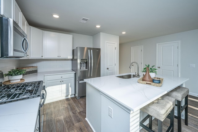 101 Orchid Bloom Cir, Moncks Corner, SC 29461 - kitchen featuring stainless steel appliances, a sink, dark wood-style flooring, decorative backsplash, and light stone counters