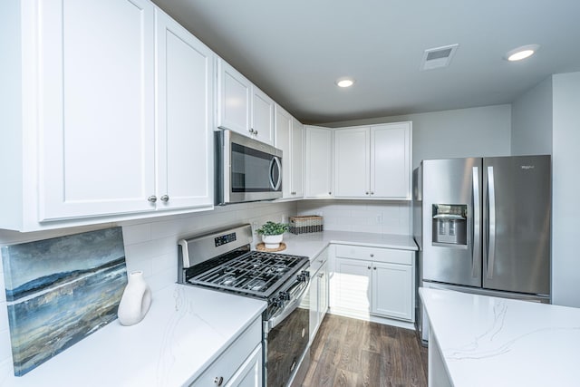 101 Orchid Bloom Cir, Moncks Corner, SC 29461 - kitchen featuring appliances with stainless steel finishes, light stone counters, dark wood finished floors, white cabinetry, and recessed lighting