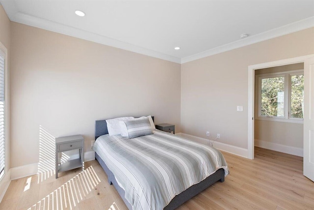 bedroom featuring crown molding and light hardwood / wood-style floors