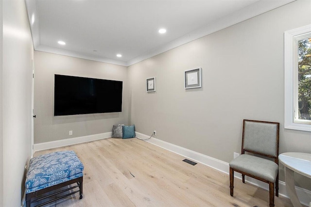 interior space with crown molding and light hardwood / wood-style floors