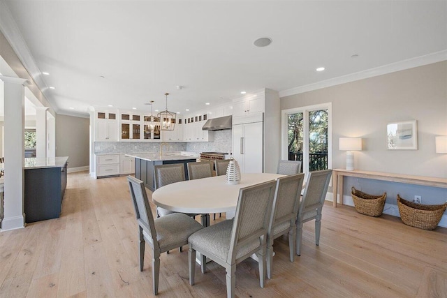 dining space featuring ornamental molding and light hardwood / wood-style floors