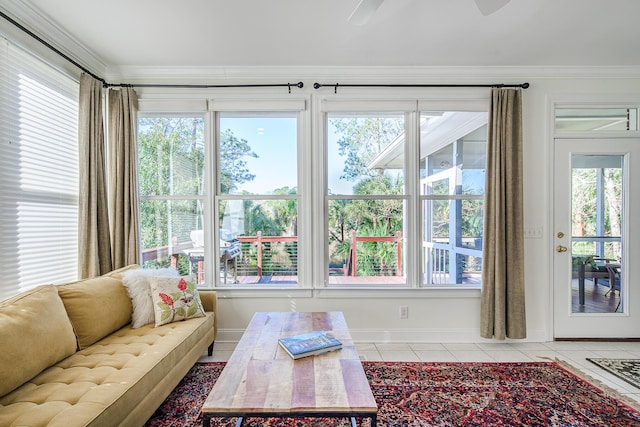 living area with light tile patterned flooring, baseboards, and ornamental molding