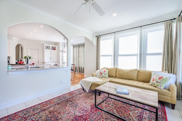 living room featuring light tile patterned floors, baseboards, and ornamental molding