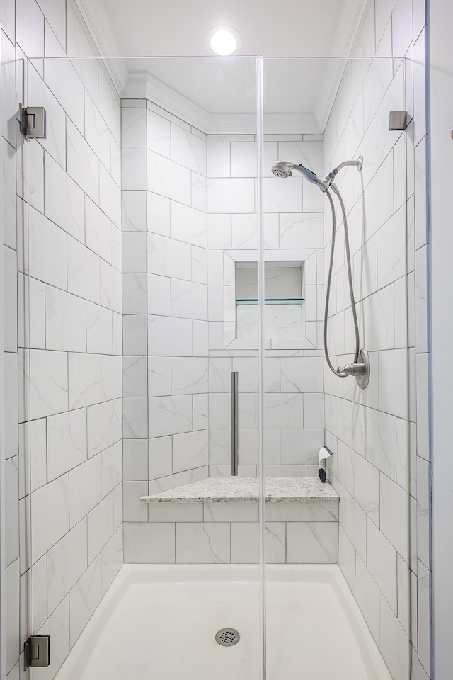 bathroom with a shower stall and crown molding